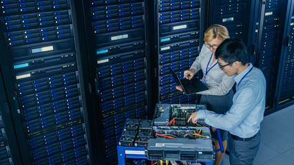 In the Modern Data Center: Engineer and IT Specialist Work with Server Racks, on a Pushcart...