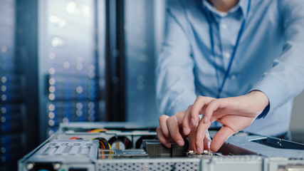 Close-up Shot in Modern Data Center: IT Engineer Installs New Hardware for Server Rack. IT...