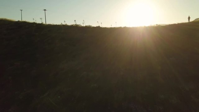Collina con prato verde al tramonto
