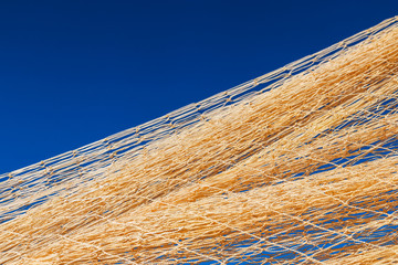 Nylon fishnet texture on the clear sky. Nautical marine background. Macro closeup.