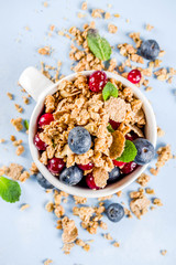 Small cup with breakfast granola, nuts and berries