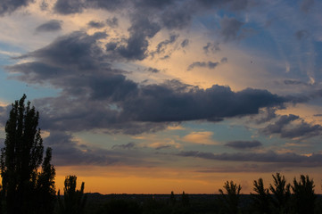 Landscape with dramatic light - beautiful golden sunset with saturated sky and clouds.