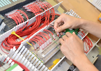 The electrician is connecting the electric cable wire. Engineer maintenance and fix the system...