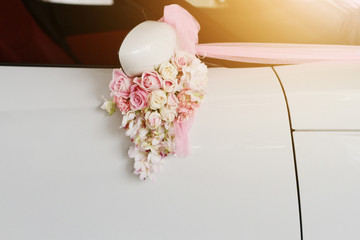 Beautiful Pink roses flower Ribbon decorated on white car door handles for wedding