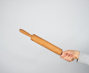 hand holding a wooden rolling pin