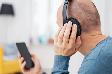 Balding middle-aged man listening to music