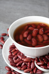 Sweet boiled red beans in white cup on concrete table.