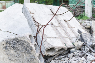 Destroyed building structures. Broken reinforced concrete blocks with reinforcement.