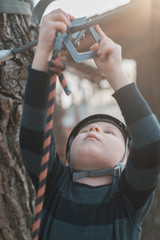 A little boy is passing an obstacle course. Active physical recreation of the child in the fresh air in the park. Training for children.