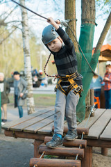 A little boy is passing an obstacle course. Active physical recreation of the child in the fresh air in the park. Training for children.