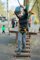 A little boy is passing an obstacle course. Active physical recreation of the child in the fresh air in the park. Training for children.