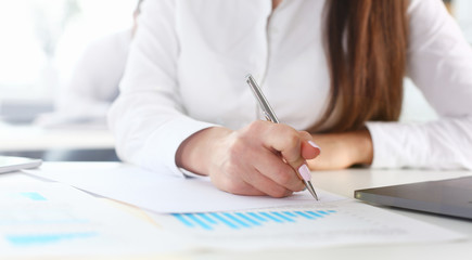 Female arm in suit hold silver pen and pad making note in office closeup. Deal consult delivery...