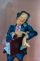 beautiful porcelain figurine of a businessman. Businessman with a diplomat talking on the phone. vertical photo