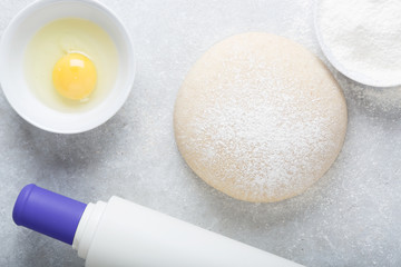 Risen or proved yeast dough for bread or pizza on a floured slate surface.