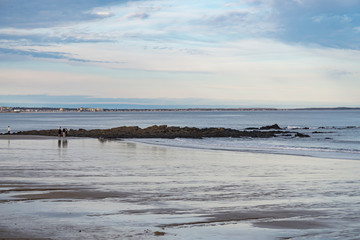 People walk on the beach in Maine, USA
