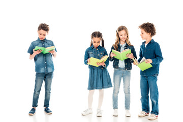 full length view of four concentrated kids reading books on white