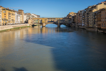 Sunny view on the Arno River and Ponte Vecchio in Florence, Italy