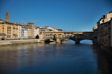 Sunny view on the Arno River and Ponte Vecchio in Florence, Italy