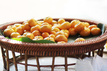 Fresh orange on banana leaves in wicker food tray. Thai buffet food tradition in event and wedding ceremony