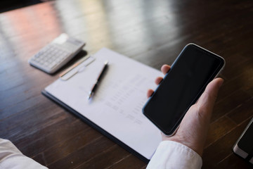 Close up of a man using mobile smart phone on the table