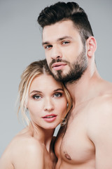 Fototapeta premium muscular man and attractive naked girl looking at camera on grey
