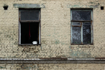 Facade of old house with opened weathered window in a poor area of city