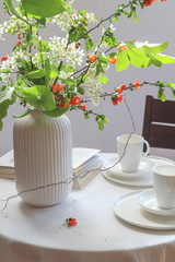 Morning table with coffee, caneles and flowers. Bright mood still life with food.