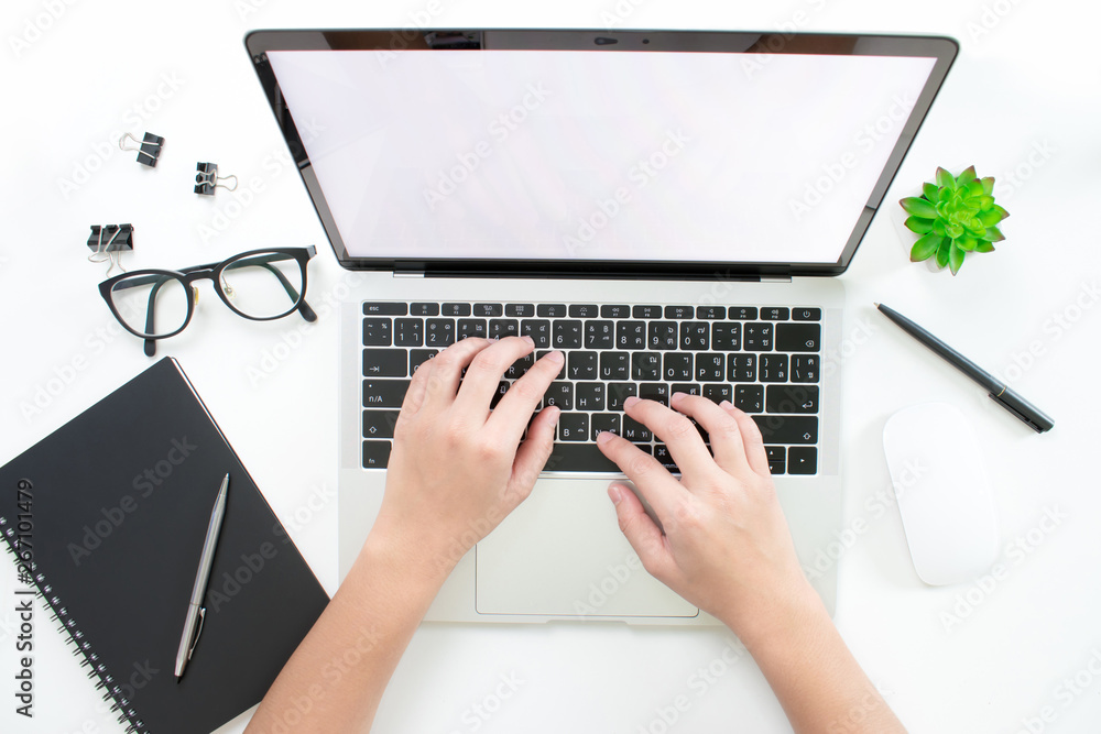 Poster men's hands are typing on a laptop computer on a modern style white desk with working equipment. the