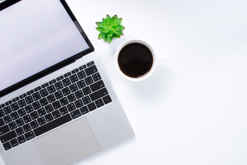 Top view of a laptop computer with a coffee cup on a modern style white desk. With copy space.