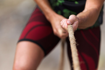 Tug of war male hands holding a rope