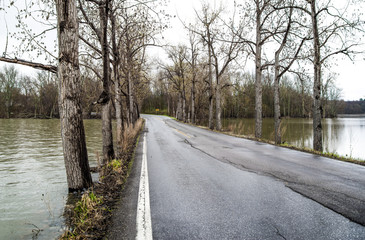 High Water:  The level of water nearly reaches the edge of a narrow causeway across the southern end of Lake Champlain on a rainy spring day in Vermont.