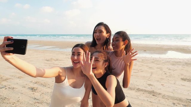 Asian girl group photography selfie with smartphone together at seaside beach summer. Young asia happy emotion and anniversary celebration. 4K resolution and slow motion.