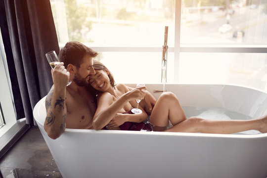 Romantic moments in the bathroom - Smiling couple bathing together.