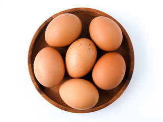 Top view of raw brown eggs on wooden plate isolated on white background. Eggs are a common ingredient in cooking.  Egg protein is a protein that can be absorbed efficiently. Food concept.