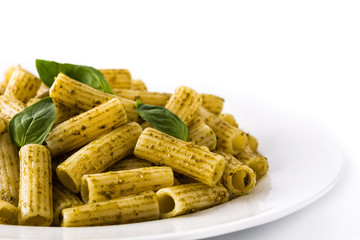 Penne pasta with pesto sauce and basil on a plate isolated on white background