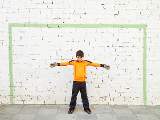 Goalkeeper with outstretched arms awaits a shot, street soccer