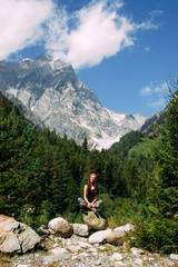 Woman tourist sitting on mountain in Svaneti in Georgia near Chalaadi glacier trek