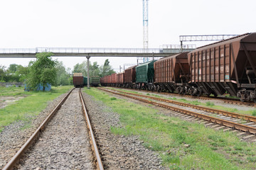 Obraz premium The train passes on a railway through the city, sunny day with blue sky and clouds. Kyiv(Kiev), Ukraine.