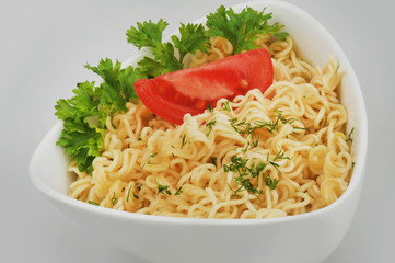 Instant vermicelli with tomato and parsley on a gray isolated background