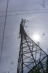 Electricity transmission pylon silhouetted against grey sky at dusk