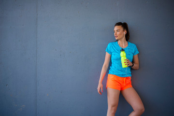 Portrait of young fit woman on wall background