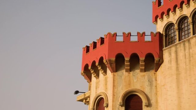Torre di un castello con merli rossi