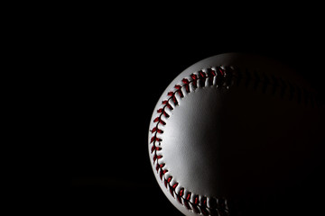 A white baseball with dark background