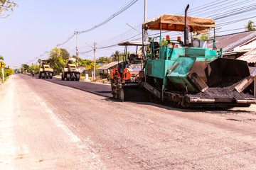 Fototapeta premium Close view on the workers and the asphalting machines, Workers making asphalt at road construction