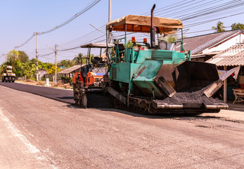 Fototapeta premium Close view on the workers and the asphalting machines, Workers making asphalt at road construction