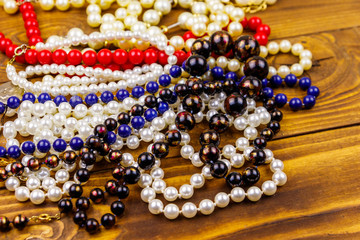 Different beads necklaces on wooden background