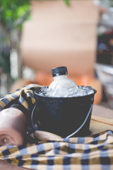 Bottles with fresh milk served in bucket.
