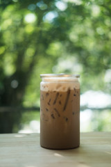Iced mocha in clear plastic bottles on wood table in coffee shop