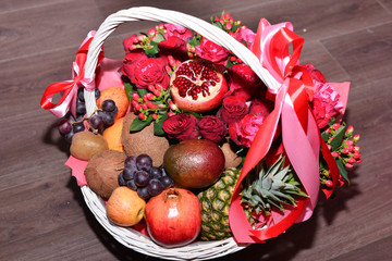 fresh natural pink roses in a wicker basket of rose on wooden background