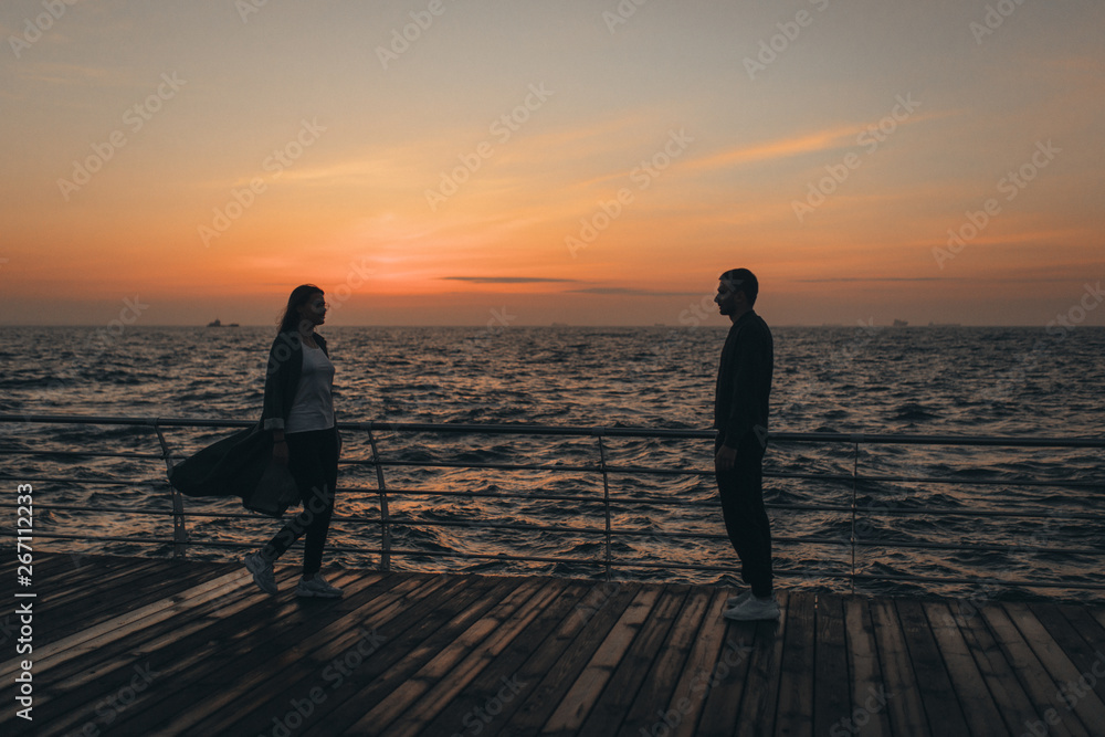 Wall mural beautiful loving couple walking at sunset